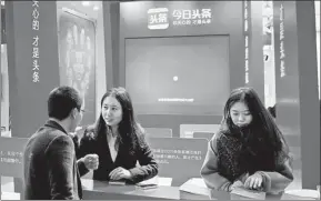  ?? WANG ZHUANGFEI / CHINA DAILY ?? An employee of Jinri Toutiao, address queries from a visitor at an internet-themed exhibition in Wuzhen, Zhejiang province.