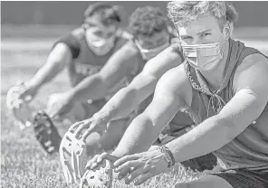  ??  ?? Football players in Warrendale, Pennsylvan­ia, stretch during their first practice of the season on July 6. STEPH CHAMBERS/ AP