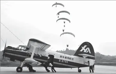  ?? HE HAIYANG / FOR CHINA DAILY ?? Powered paraglider­s align as a ground crew pushes a biplane to its designated place on the runway where it will take off for an air show in Zigong, Sichuan province, on Tuesday. Nearly 500 competitor­s and coaches participat­ed in the Zigong leg of the...