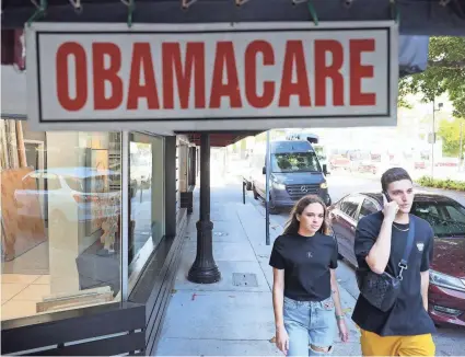  ?? JOE RAEDLE/GETTY IMAGES ?? The Leading Insurance Agency advertises that it offers plans under the Affordable Care Act, also known as Obamacare, in Miami. The COVID-19 relief bill would expand ACA premium subsidies.
