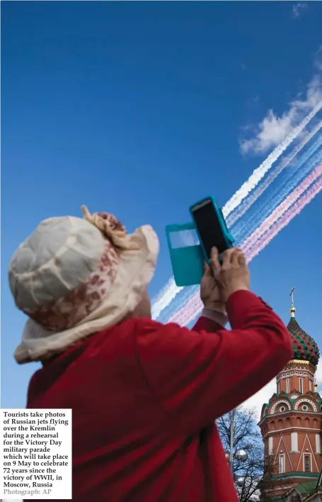  ?? Photograph: AP ?? Tourists take photos of Russian jets flying over the Kremlin during a rehearsal for the Victory Day military parade which will take place on 9 May to celebrate 72 years since the victory of WWII, in Moscow, Russia