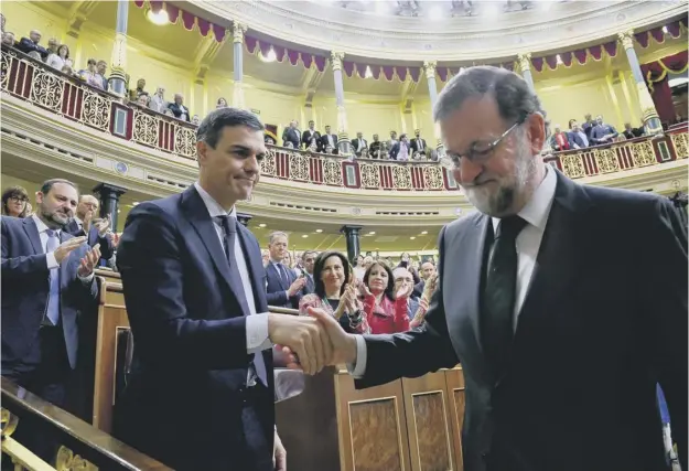  ??  ?? Spain’s new prime minister, the Socialist leader Pedro Sanchez, left, shakes hands with his predecesso­r Mariano Rajoy after the former premier lost a vote of confidence