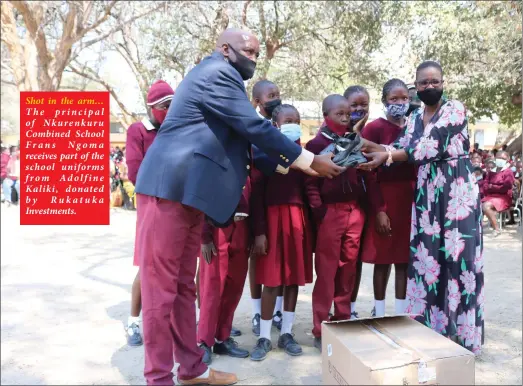  ??  ?? Shot in the arm… The principal of Nkurenkuru Combined School Frans Ngoma receives part of the school uniforms from Adolfine Kaliki, donated by Rukatuka Investment­s.