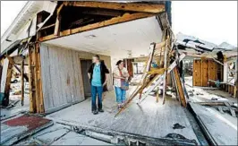  ?? GERALD HERBERT/AP ?? Lanie Eden and her husband, Ron, survey the damage at the vacation home they have rented for years in Mexico Beach. “Basically, we lost ‘old Florida.’ It’s all gone,” she said.