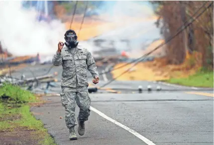  ?? TREVOR HUGHES/USA TODAY ?? Orlando Corpuz of the Hawaiian Air National Guard signals a sulfur dioxide reading of zero.