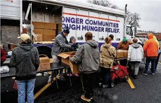  ?? BILL LACKEY / STAFF ?? Volunteers pass out food at Second Harvest Food Bank’s Mobile Pantry on Wednesday in the parking lot of the First United Church of Christ in Springfiel­d.