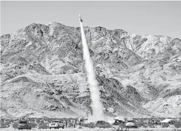  ?? Matt Hartman photos / Associated Press ?? “Mad” Mike Hughes’ home-made rocket launches near Amboy, Calif. The rocket scientist, who believes the earth is flat, propelled himself about 1,875 feet into the air before a parachute drop and a hard landing.