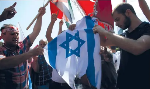  ?? (Reuters) ?? TURKS SET FIRE to an Israeli flag during a protest after Friday prayers in Istanbul in July.