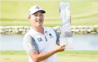  ?? Associated Press ?? ↑
KH Lee holds up the AT&T Byron Nelson golf tournament trophy after winning in Mckinney.