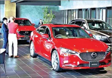  ?? THE YOMIURI SHIMBUN ?? New cars are displayed at Kanto Mazda’s Itabashi main branch in Itabashi ward, Tokyo.