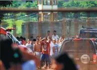  ?? CLAUDIO REIS/O POPULAR VIA ASSOCIATED PRESS ?? Prisoners try to contact relatives after a riot at the Colonia Agroindust­rial prison in Goias, Brazil, on Monday.