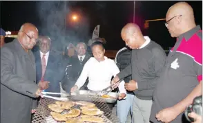  ?? ?? Minister of Public Service Mabulala Maseko, The Mayor of Manzini town Quinton Els (2nd R) and Philani Maswati’s Chairman and Member of Parliament, Lutfo Dlamini braaing meat during the launch.