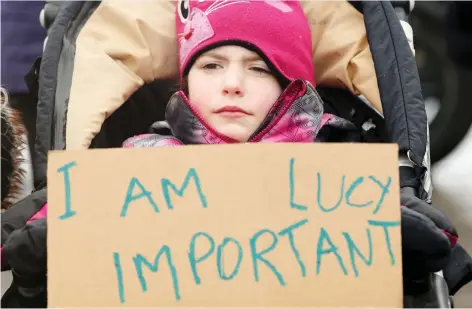  ?? JULIE OLIVER ?? Lucy Perlin, who is six years old and just learning to use language, stands outside Social Services Minister Lisa MacLeod’s Barrhaven office Friday as demonstrat­ors protest for a second consecutiv­e week against changes in funding for autistic children.