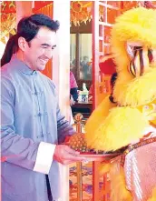  ??  ?? Hotel manager Rex Benhur Caballes offers auspicious fruits, completing the traditiona­l Chinese Lion Dance ceremony of the hotel