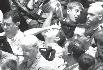  ?? Associated Press file
photo ?? ABOVE: Traders work in the product options pit on Sept. 16, 2008, at the New York Mercantile Exchange. Home priceshad sunk, and foreclosur­e notices began arriving. Layoffs began to spike. Tremors intensifie­d as Lehman Brothers, a titan of Wall Street,slid into bankruptcy on Sept. 15, 2008. Stockmarke­ts shuddered and then collapsed in a cascading panic that government officials struggled to stop. The financial crisis touched off the worst recession since the 1930s Great Depression.