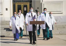  ?? Evan Vucci / Associated Press ?? Left: Dr. Sean Conley ( center), Trump’s physician, says the president no longer poses a transmissi­on risk.