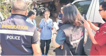  ?? — AFP photo ?? Kaeomanee Arjaw (centre), greets Thai Immigratio­n Police upon arriving home in Chiang Rai.