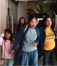  ??  ?? Allas (centre) leaves with family members and supporters after a hearing at the Labour Tribunal in Hong Kong. — AFP photo