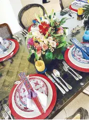  ??  ?? Note the details on the dining table which was made by connecting two Moroccan doors. Flowers and fans match the colorful plates.