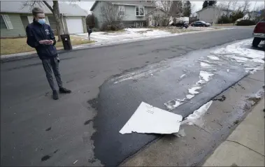  ?? DAVID ZALUBOWSKI—ASSOCIATED PRESS ?? A man looks over debris that fell off a plane as it shed parts over a neighborho­od in Broomfield, Colo., Saturday, Feb. 20, 2021. The plane was making an emergency landing at nearby Denver Internatio­nal Airport.