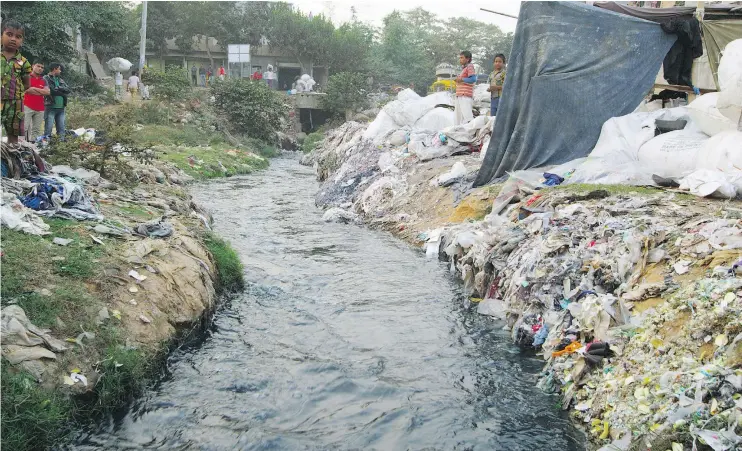  ?? — DAVID MCILVRIDE ?? On the outskirts of Dhaka, Bangladesh, heavily polluted run-off from one of hundreds of local “fast-fashion” textile plants flows through a local community.