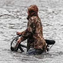  ?? Chandan Khanna / AFP via Getty Images ?? A man walks his bicycle through a street flooded by Hurricane Sally on Wednesday in Pensacola, Fla.