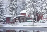  ??  ?? The rambling Pan-Abode-style log cottage lies nestled in six acres of woods on a picture-postcard winter day.