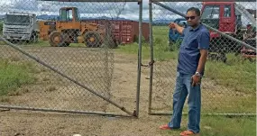  ?? Photo: Charles Chambers ?? Jack’s Autoworld General Manager Farzaad Azaria at the yard in Naisoso where the truck parts were dropped off. At the back of the loader are the two containers that were to store the parts.