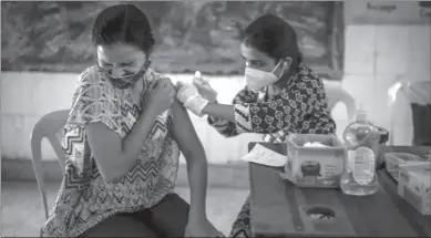  ?? ?? NEW DELHI
A woman reacts as a health worker inoculates her during a vaccinatio­n drive against coronaviru­s inside a school in New Delhi, India. India is nearing a milestone of administer­ing a total of one billion doses against COVID-19. -AP