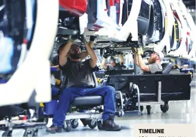  ?? STAFF PHOTO BY ERIN O. SMITH ?? Volkswagen employees work beneath vehicles moving down the assembly line at the Chattanoog­a Volkswagen Plant in 2017.