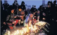  ??  ?? BRIGHT TRIBUTE People light candles in Trafalgar Square