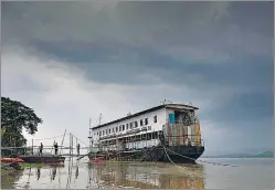  ?? PTI ?? An NDRF boat on the Brahmaputr­a banks as dark clouds cover the sky in Guwahati on Thursday.