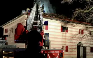  ??  ?? I soccorsi I vigili del fuoco impegnati nello spegniment­o. Sotto, il rogo che ha devastato la palazzina