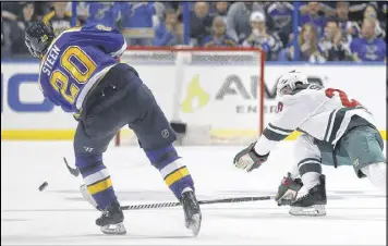  ?? JEFF ROBERSON / ASSOCIATED PRESS ?? The Blues’ Alexander Steen scores into an empty net Sunday as the Wild’s Ryan Suter tries unsuccessf­ully to block the shot with his stick.