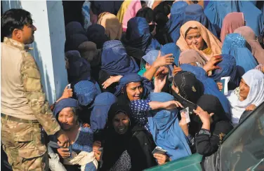  ?? Noorullah Shirzada / AFP via Getty Images ?? Women gather in a crowd at a soccer stadium, where they were trying to get visas to enter Pakistan.