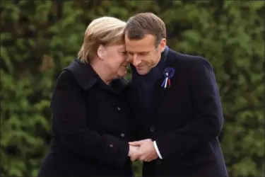  ?? PHILIPPE WOJAZER — POOL PHOTO VIA AP ?? French President Emmanuel Macron and German Chancellor Angela Merkel are head to head after unveiling a plaque in the Clairiere of Rethondes during a commemorat­ion ceremony for Armistice Day, 100 years after the end of the First World War, in Compiegne, North of Paris, France, Saturday.