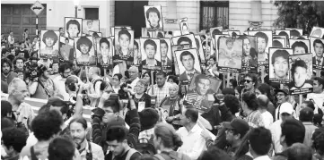  ??  ?? People holding pictures of victims of the guerrilla conflict in the 80s and 90s march against Kuczynski’s pardon for Fujimori in Lima, Peru. — Reuters photo