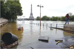  ??  ?? PARIS: In this June 4, 2016 file photo, a woman, at right, takes photos of the flooded banks of the Seine river. — AP