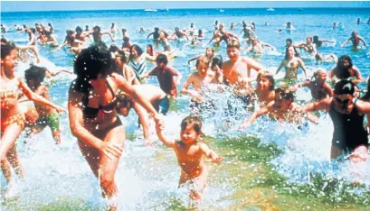  ?? UNIVERSAL STUDIOS PHOTOS VIA THE ASSOCIATED PRESS ?? Beachgoers run from the water in a scene from the 1975 blockbuste­r ”Jaws.” The film changed the way Hollywood did business.