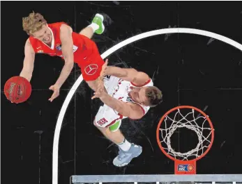  ?? FOTO: IMAGO ?? Die Basketball­welt von oben: Es geht hoch hinaus bei Per Günther (links) und seinen Ulmern, Bambergs Leon Radosevic muss sich strecken.