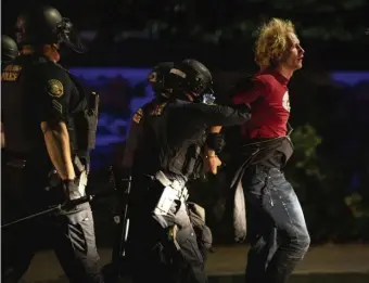  ?? AP FILE PHOTOS ?? PLENTY OF UNREST: Police make arrests on the scene of protests at a Portland Police precinct in Portland, Ore., on Aug. 30. At top, a protester screams at police on Sept. 5 in Portland.