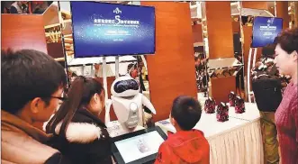  ?? PHOTOS PROVIDED TO CHINA DAILY ?? Visitors show their interest in service robots displayed at Kuntai Hotel Beijing Wangjing during a recent celebratio­n event.