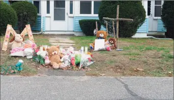  ?? Peter Yankowski / Hearst Connecticu­t Media ?? A memorial has been set up outside a Plymouth home where police say two children were shot. A 15-year-old was killed and a 7-year-old was seriously injured, police said.