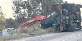  ??  ?? Tow truck lies on its side after toppling over during recovery yesterday