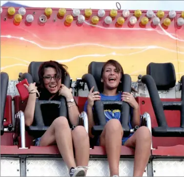  ??  ?? The Washington County Fair had lots to do for the entire family, from animals to carnival rides to live music, pig races and concession food. Vanessa Salto and Candice Navarro, students at Farmington High, enjoy the Double Shock, one of the thriller...
