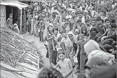  ?? AP/A.M. AHAD ?? Rohingya Muslims wait for aid Wednesday at a refugee camp in Ukhiya, Bangladesh.