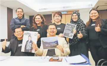  ??  ?? Lee (seated left) joins Ik Pahon (seated right), Livan (standing second left) and other members of the committee in holding up leaflets and posters highlighti­ng Donnie Yen’s first-time appearance in Kuching in conjunctio­n with Aiffa 2017.