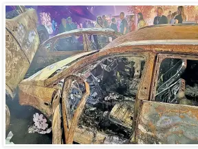  ?? ?? HELL ON EARTH: Scorched cars recovered from the Nova Music Festival are displayed inside the Expo Tel Aviv convention center — stark reminders of Hamas’ terror. Western volunteers tour Ofakim (below).