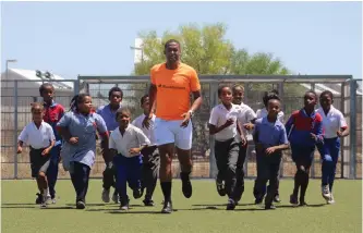  ?? KEAGAN MITCHELL ?? THE manager of the Run4School­s Foundation in Mitchells Plain, Frank Steyn, who also performs coaching duties at the foundation, runs with pupils at Northwood Primary School in Woodlands. |