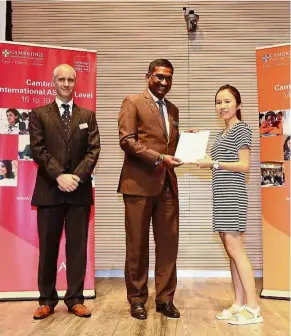  ??  ?? Well done: Wern Shern (right) received her certificat­e from Deputy Education Minister Datuk P Kamalanath­an while Cambridge Internatio­nal Examinatio­ns Southeast Asia and Pacific regional director Dr Ben Schmidt (left) looks on.